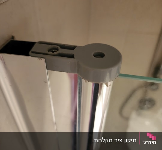 תקריב של ציר עליון של דלת מקלחון זכוכית